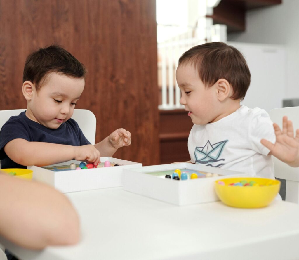 Two children playing with toys under the supervision of their mother in a cozy home setting.